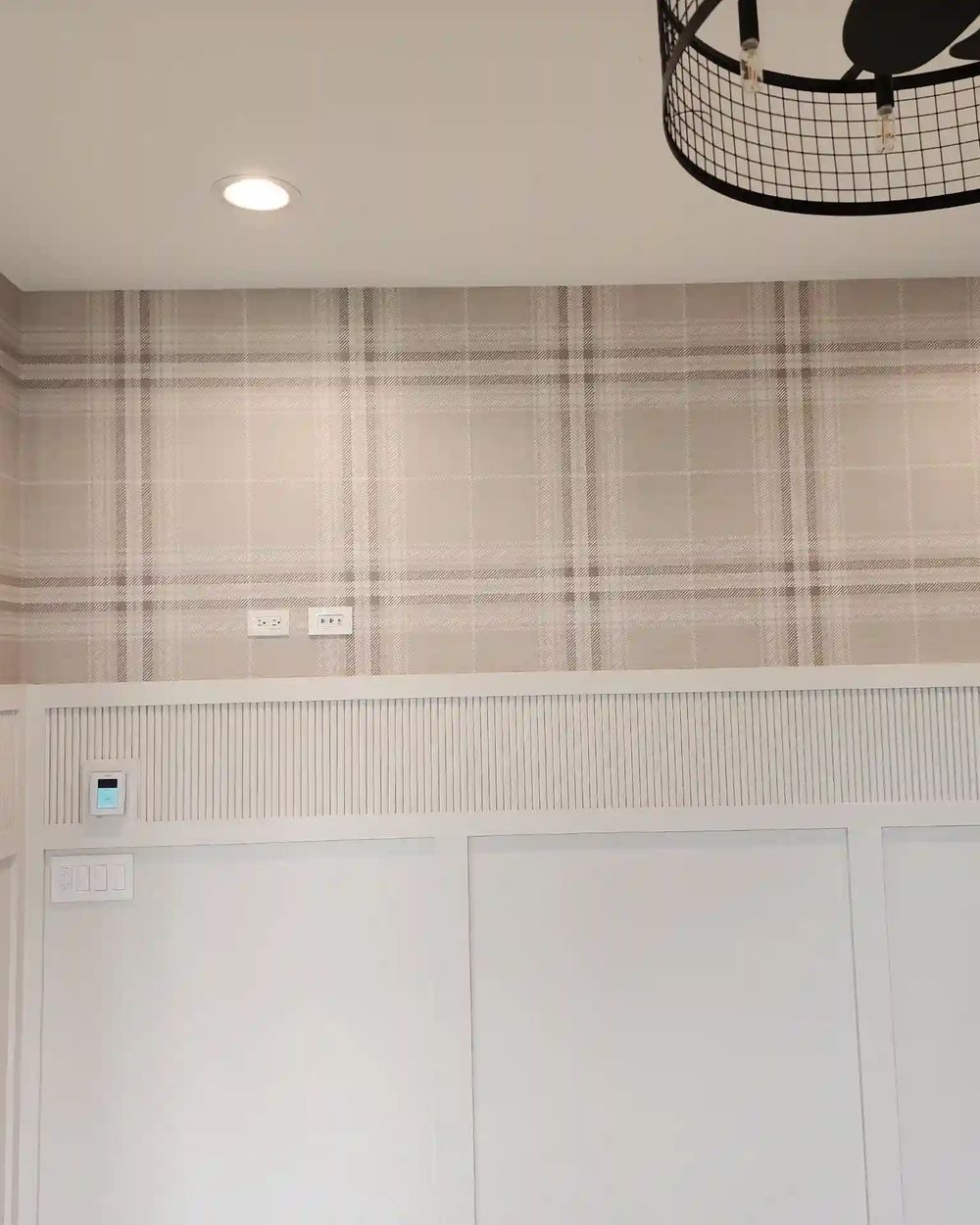 Soft taupe plaid wallpaper above white board-and-batten wainscoting