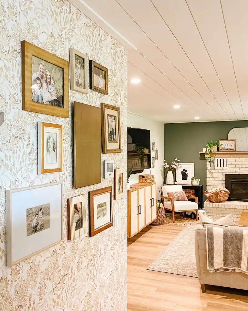Bright living room with a white shiplap ceiling, a gallery wall on botanical wallpaper and a brick fireplace